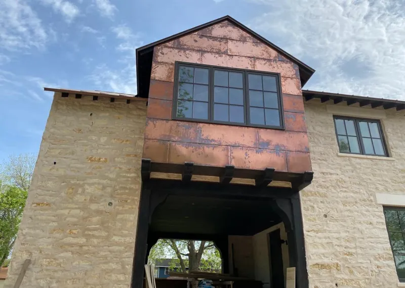 Copper metal panel facade on a stone building for Skylight Installation in Bethany